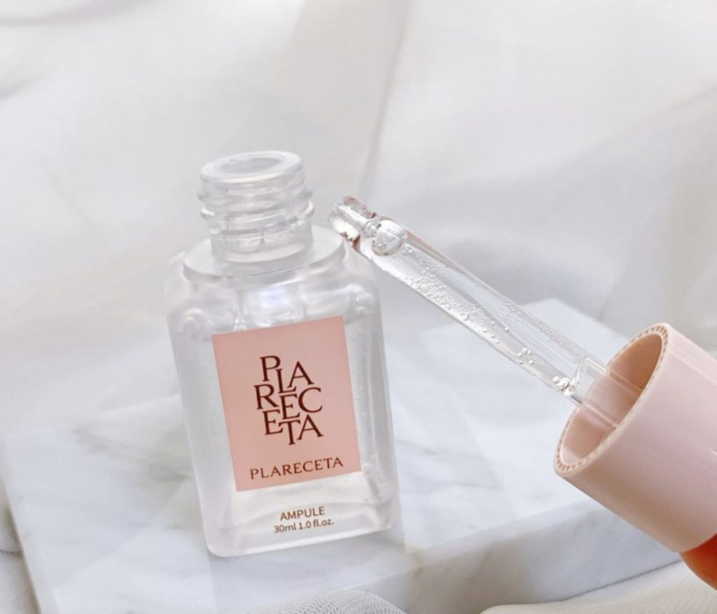 Close-up of PLARECETA Ampoule with dropper showing clear lightweight serum texture on marble background Close-up of PLARECETA Ampoule with dropper showing clear lightweight serum texture on marble background