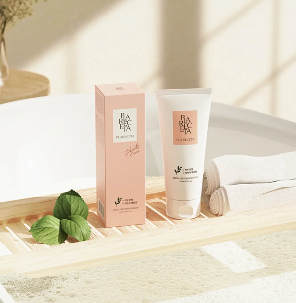 PLARECETA Greentea Foam Cleanser with packaging placed on a wooden bath tray with fresh green leaves and towels